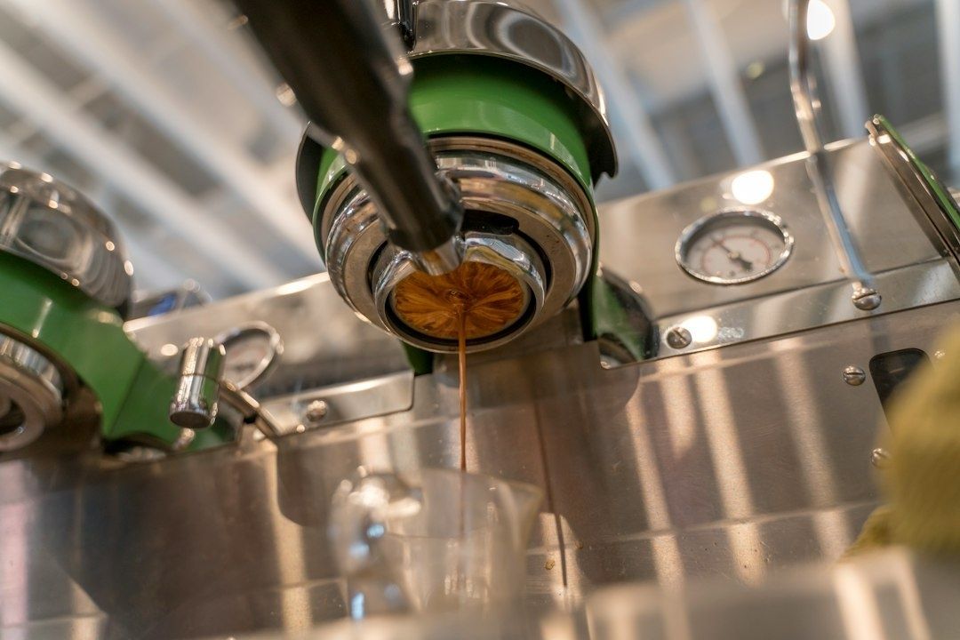 Stainless steel brewing equipment dispensing a dark amber liquid